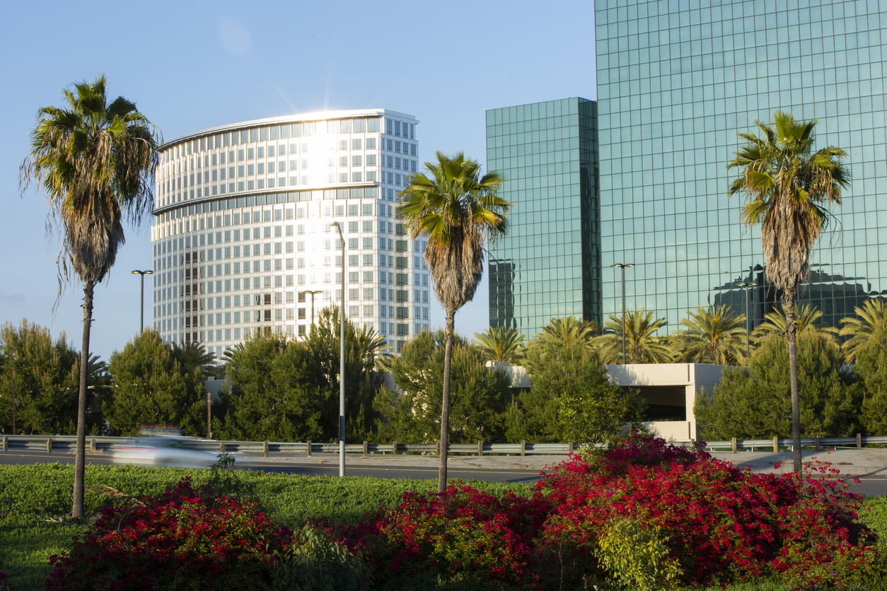 The image shows a low skyline of Costa Mesa and introduces the guide to shopping at South Coast Plaza.