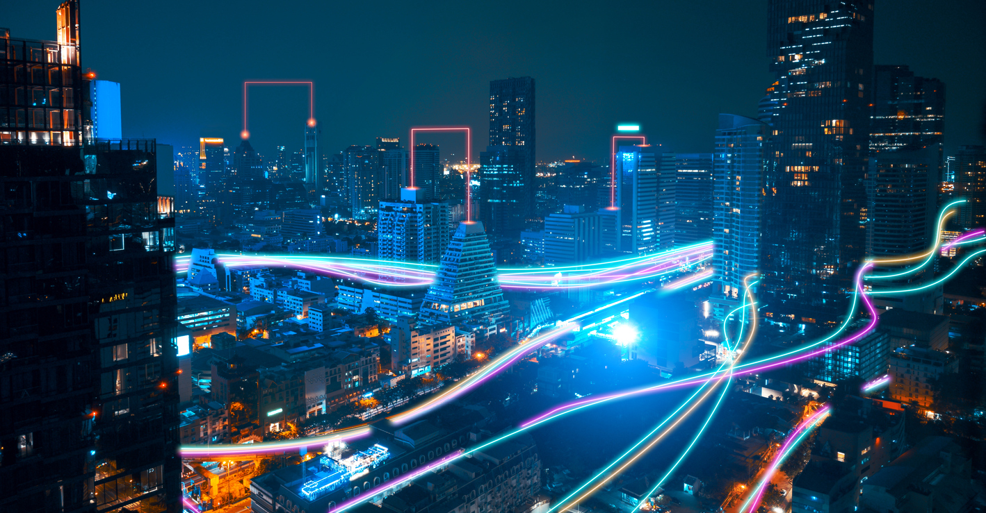 The image shows digital lines over a city to represent how fiber optics were invented.