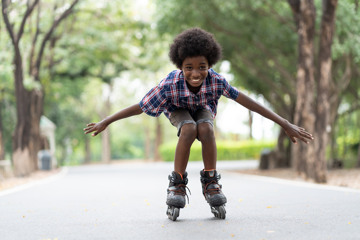 The image shows an African American boy skating outside to represent the best roller skates for your child.